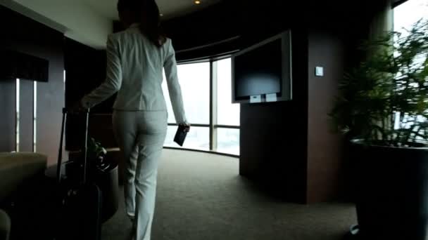 Businesswoman in hotel viewing cityscape — Stock Video