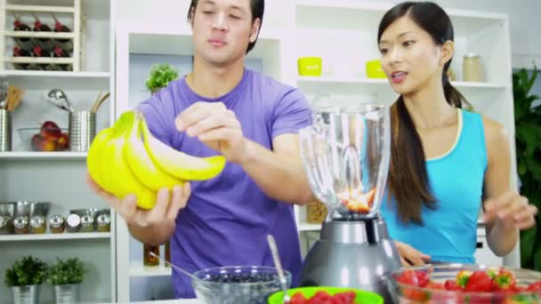 Pareja haciendo nutritiva bebida fresca de zumo de fruta casero — Vídeos de Stock