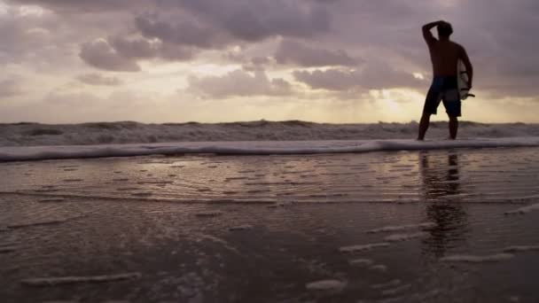 Surfista en la playa viendo olas — Vídeos de Stock