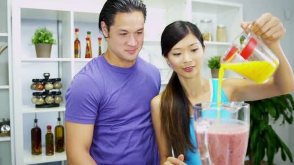 Пара делает питательные свежие домашние фруктовые соки — стоковое видео