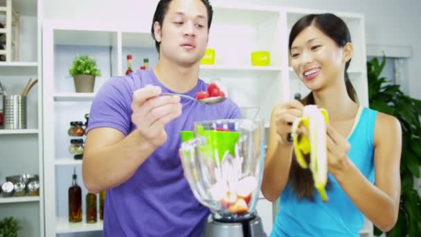 Casal chinês asiático preparando Smoothie de frutas caseiro saudável — Vídeo de Stock