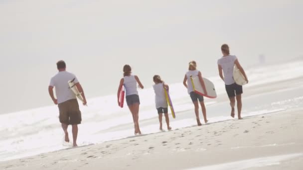 Eltern mit Töchtern rennen am Strand — Stockvideo