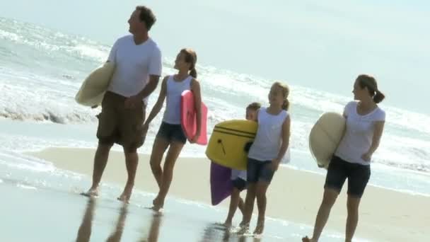Родители с дочерьми прогуливаются по пляжу — стоковое видео