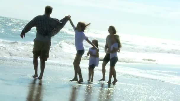 Meisjes spelen met ouders op strand — Stockvideo