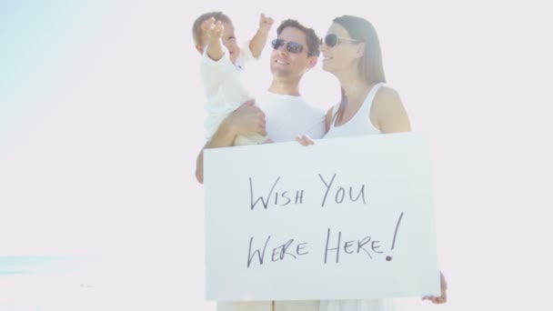 Family on beach holding message board — Stock Video