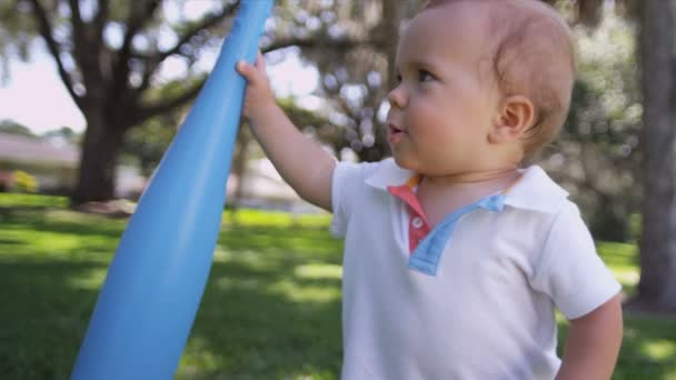 Niño jugando bate de béisbol de plástico — Vídeos de Stock