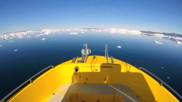 Barco flotando en el océano con icebergs a la deriva — Vídeo de stock