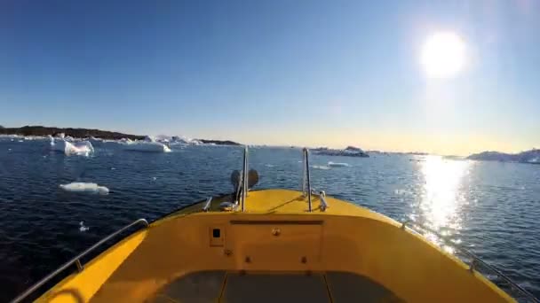 Boot in de oceaan met ijsbergen drijvend — Stockvideo