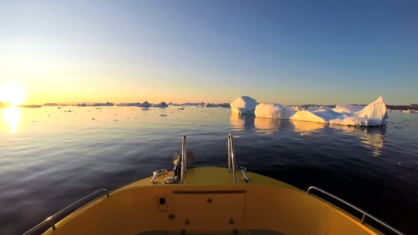 Barco flotando en el océano con icebergs a la deriva — Vídeos de Stock