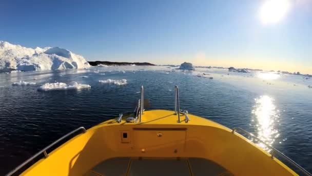 Barco flotando en el océano con icebergs a la deriva — Vídeos de Stock