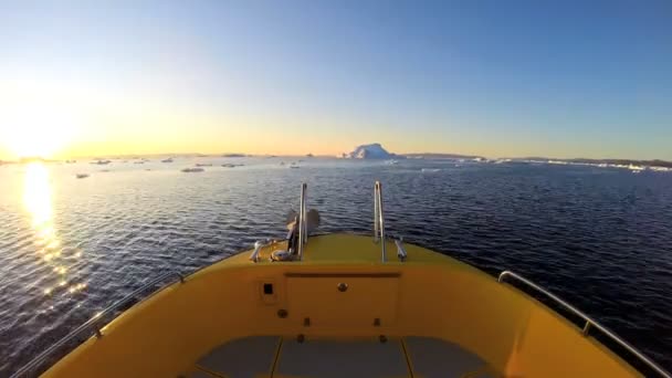 Barco flotando en el océano con icebergs derretidos — Vídeo de stock