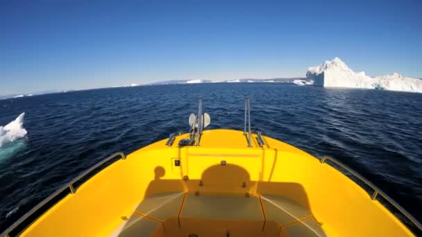 Лодка плавающая в океане с дрейфующими айсбергами — стоковое видео