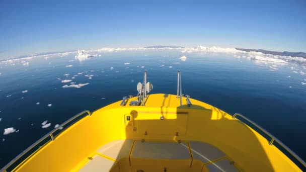 Barca plutind în ocean cu aisberguri în derivă — Videoclip de stoc