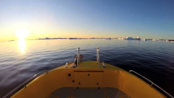Лодка плавающая в океане с тающими айсбергами — стоковое видео