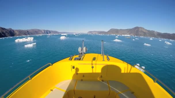 Båt flyter i havet med drivande isberg — Stockvideo