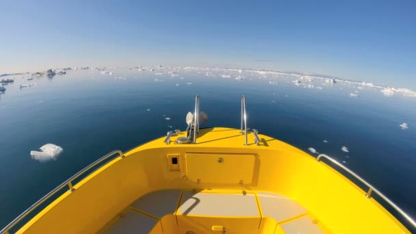 Barco flotando en el océano con icebergs a la deriva — Vídeo de stock