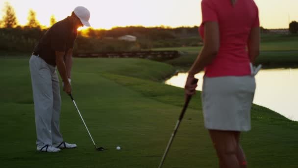 Man och kvinna spelar golf — Stockvideo