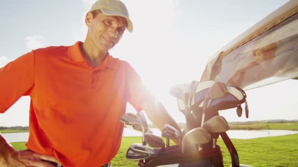 Профессиональный игрок в гольф и гольф-кар с оборудованием — стоковое видео