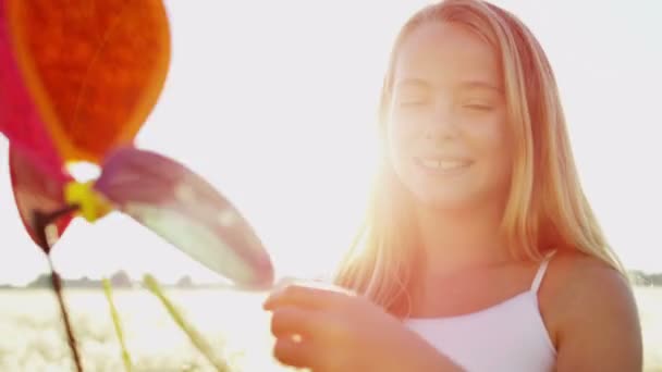 Kız açık havada renkli yel değirmeni oyuncakla oynamak — Stok video