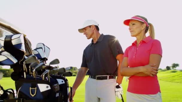 Мужчины и женщины гольфисты на поле для гольфа — стоковое видео