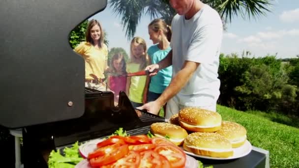 Ouders met dochters grillen van vlees van de barbecue — Stockvideo