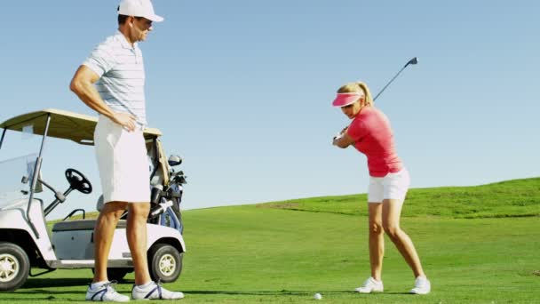 Мужчина и женщина играют в гольф — стоковое видео