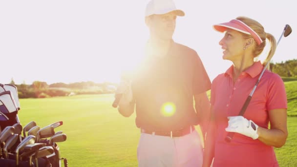 Manliga och kvinnliga golfspelare på golfbana — Stockvideo