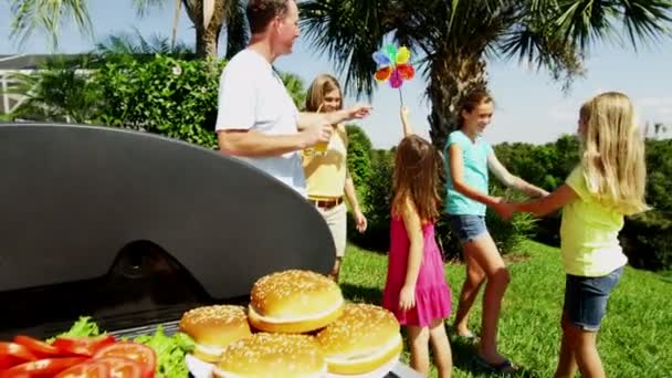 Ouders met dochters grillen van vlees van de barbecue — Stockvideo