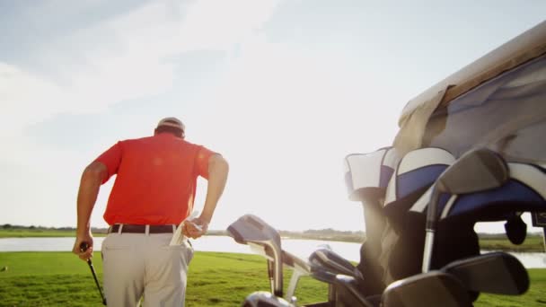 Jogador de golfe masculino profissional e carrinho de golfe com equipamento — Vídeo de Stock