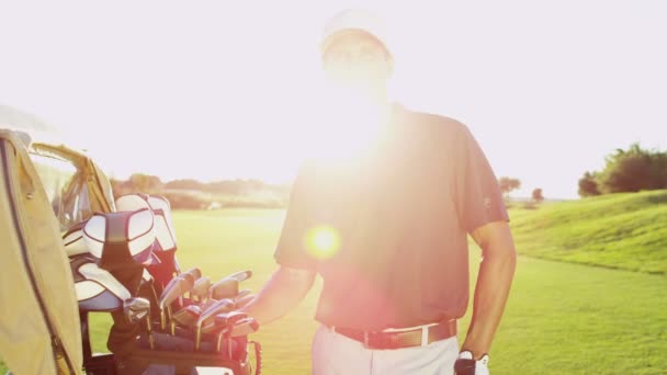 Joueur de golf avec des clubs de golf en plein air — Video