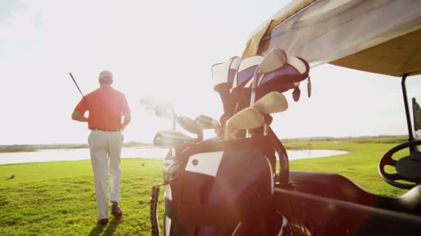 Professional male golf player and golf cart with equipment — Stock Video