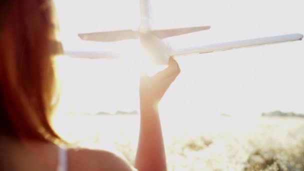 Молодая девушка играет с игрушечным самолетом — стоковое видео