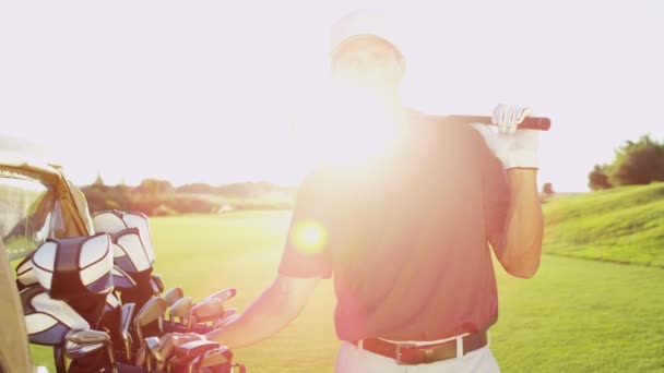 Golfspeler met golfclubs outdoors — Stockvideo