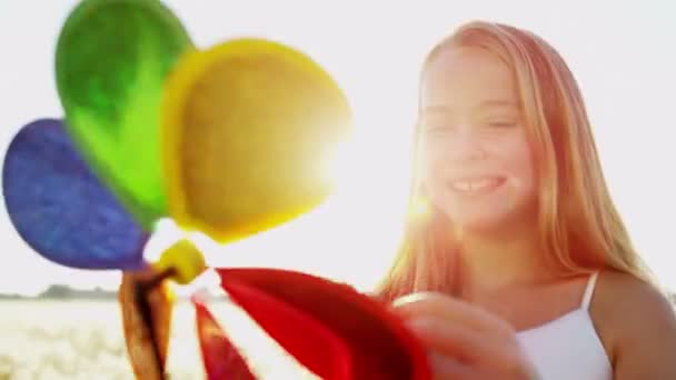 Menina ao ar livre jogando com colorido moinho de vento brinquedo — Vídeo de Stock