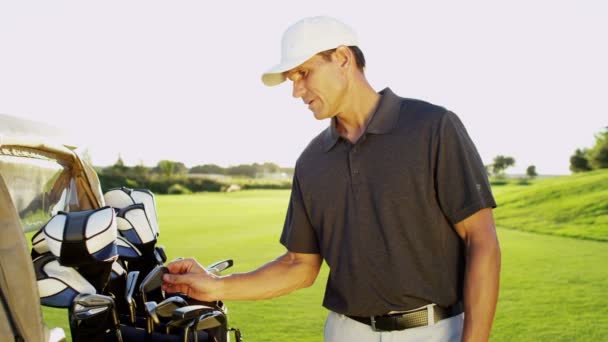 Golfspeler met golfclubs outdoors — Stockvideo