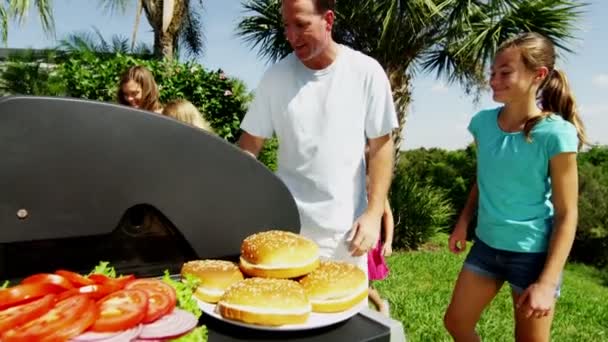 Ouders met dochters grillen van vlees van de barbecue — Stockvideo