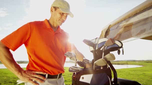 Hivatásos férfi golf-lejátszó és a golfkocsi berendezéssel — Stock videók