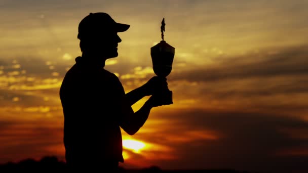 Silhouette eines männlichen Golfprofis mit Trophäe — Stockvideo