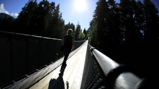 Woman walking on Capilano suspended walkway — Stock Video