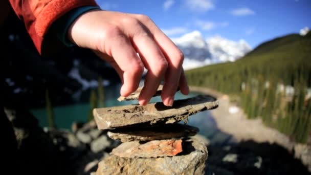 Kvinnliga vandrare gör stenpyramid — Stockvideo