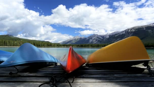 Wooden kayaks lying on jetty at lake — Stock Video