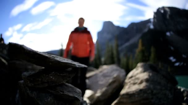 Female hiker making stone pyramid — Stock Video