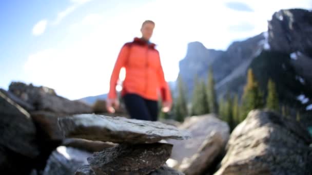 Femme randonneur faisant pyramide de pierre — Video