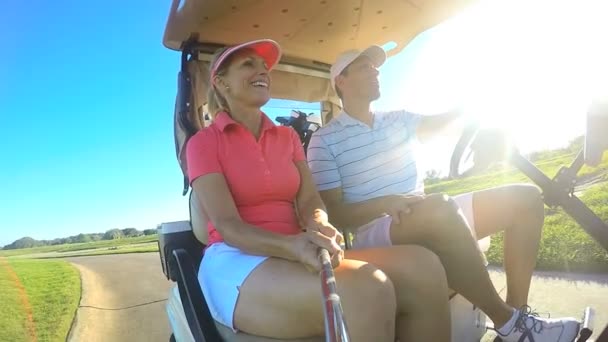 Пара гравців в гольф за кермом баггі-кошик — стокове відео