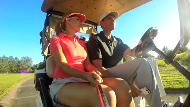 Couple of golf players driving buggy cart — Stock Video