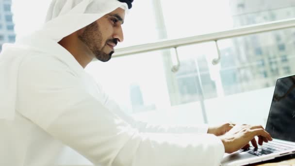 Businessman in traditional dress working on laptop — Stock Video