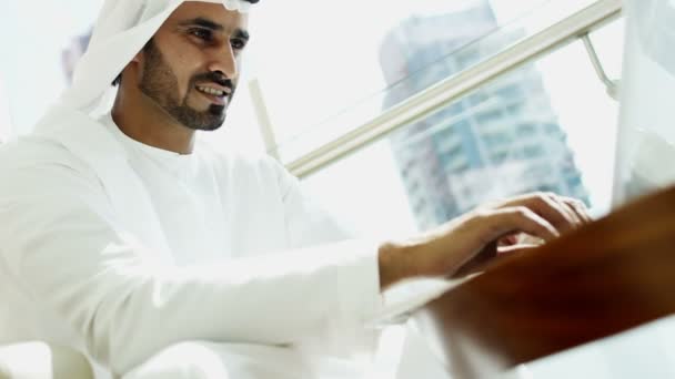 Businessman in traditional dress working on laptop — Stockvideo