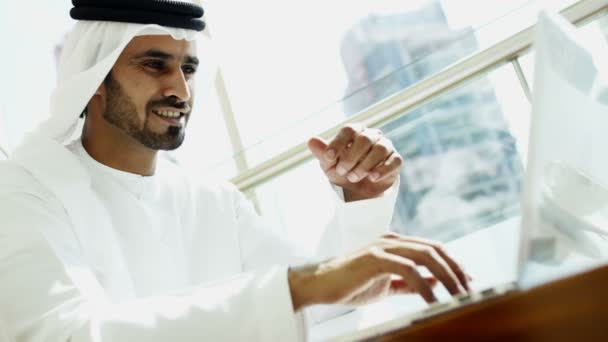 Businessman in traditional dress working on laptop — Stock Video