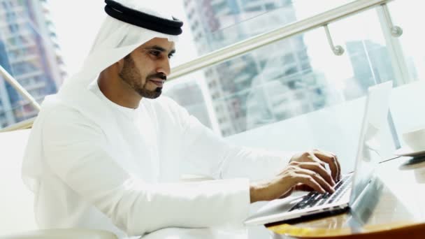 Businessman in traditional dress working on laptop — Stock Video