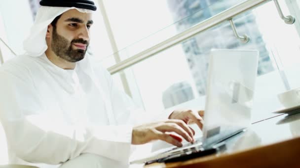 Businessman in traditional dress working on laptop — Stockvideo